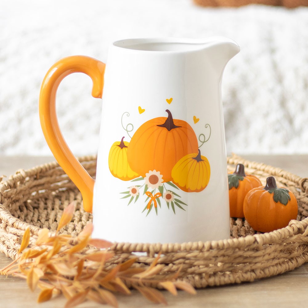 White jug with orange handle and pumpkin design