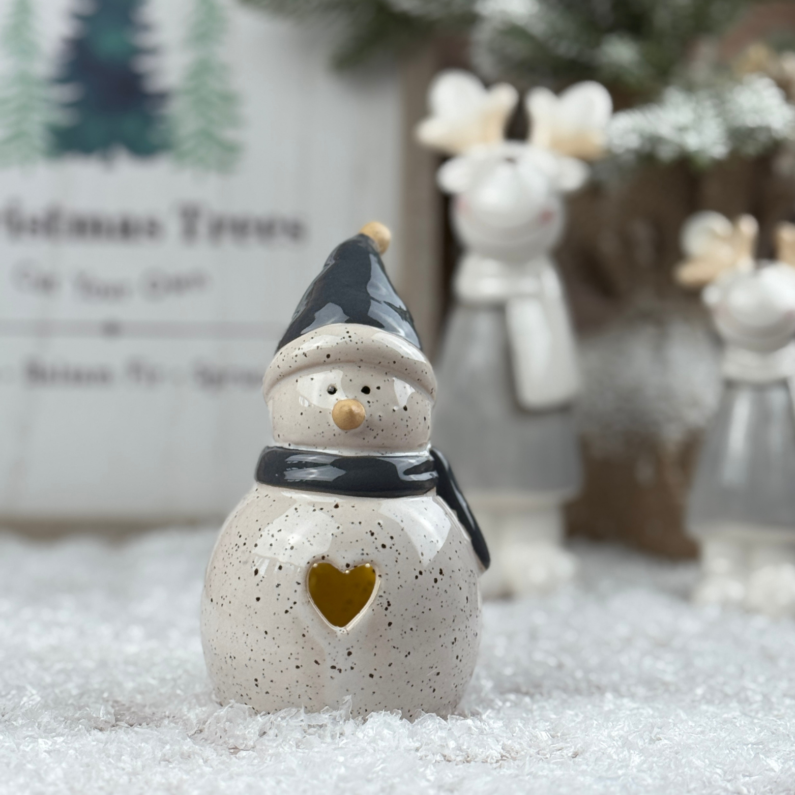 Ceramic snowman with a heart in his tummy and a light inside.
