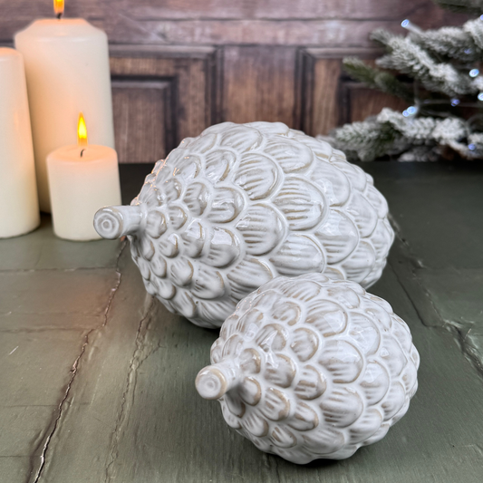 two glazed pinecones with candles