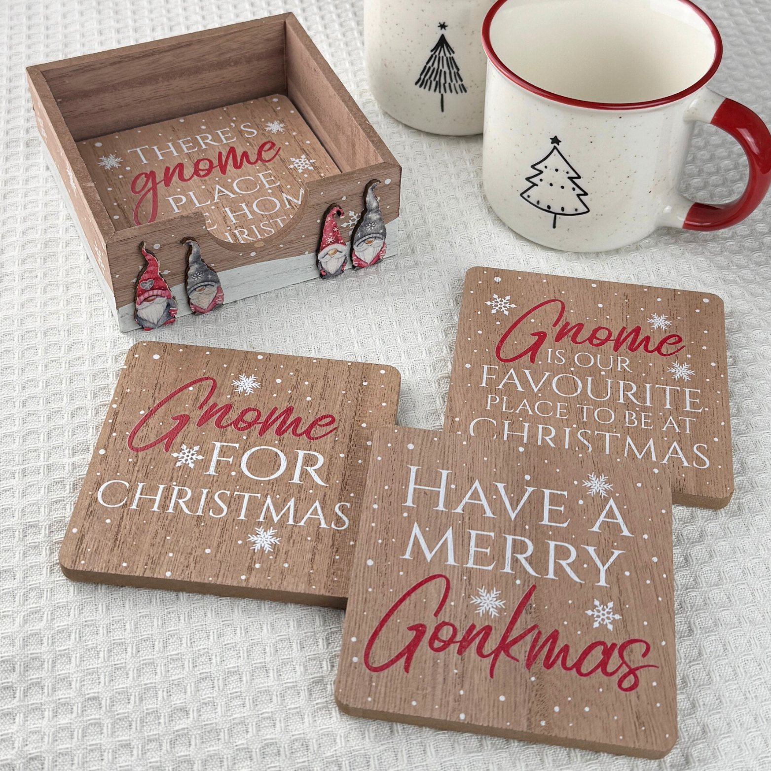 set of four gnome goasters each with a festive message presented in a wooden holder with gnomes on the front