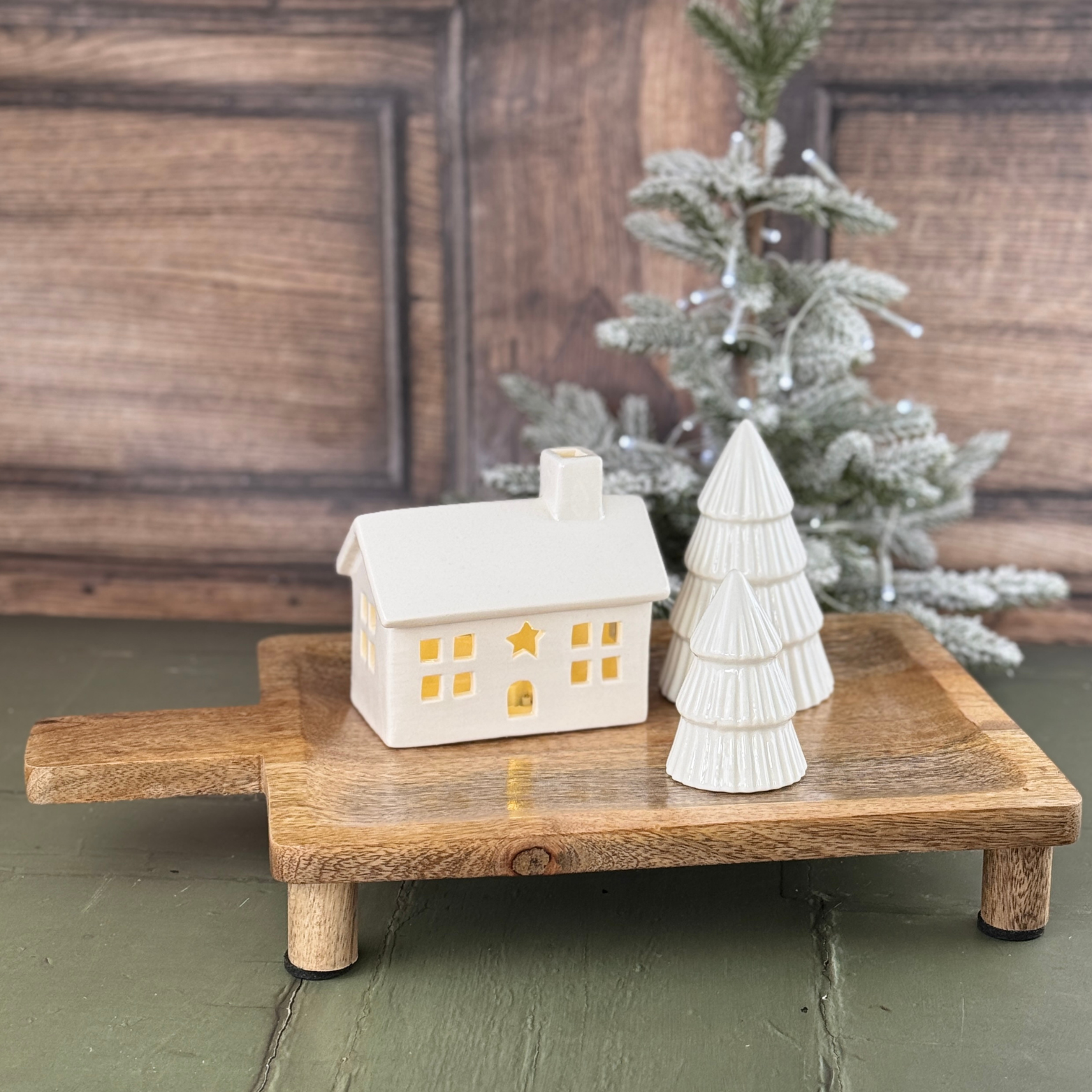 large rectangular board with light up house and ceramic tree