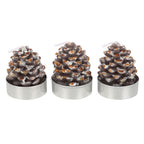 Three pine cone-shaped candles on a white background