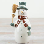 Ceramic snowman figurine with a broom, green hat and brown scarf.