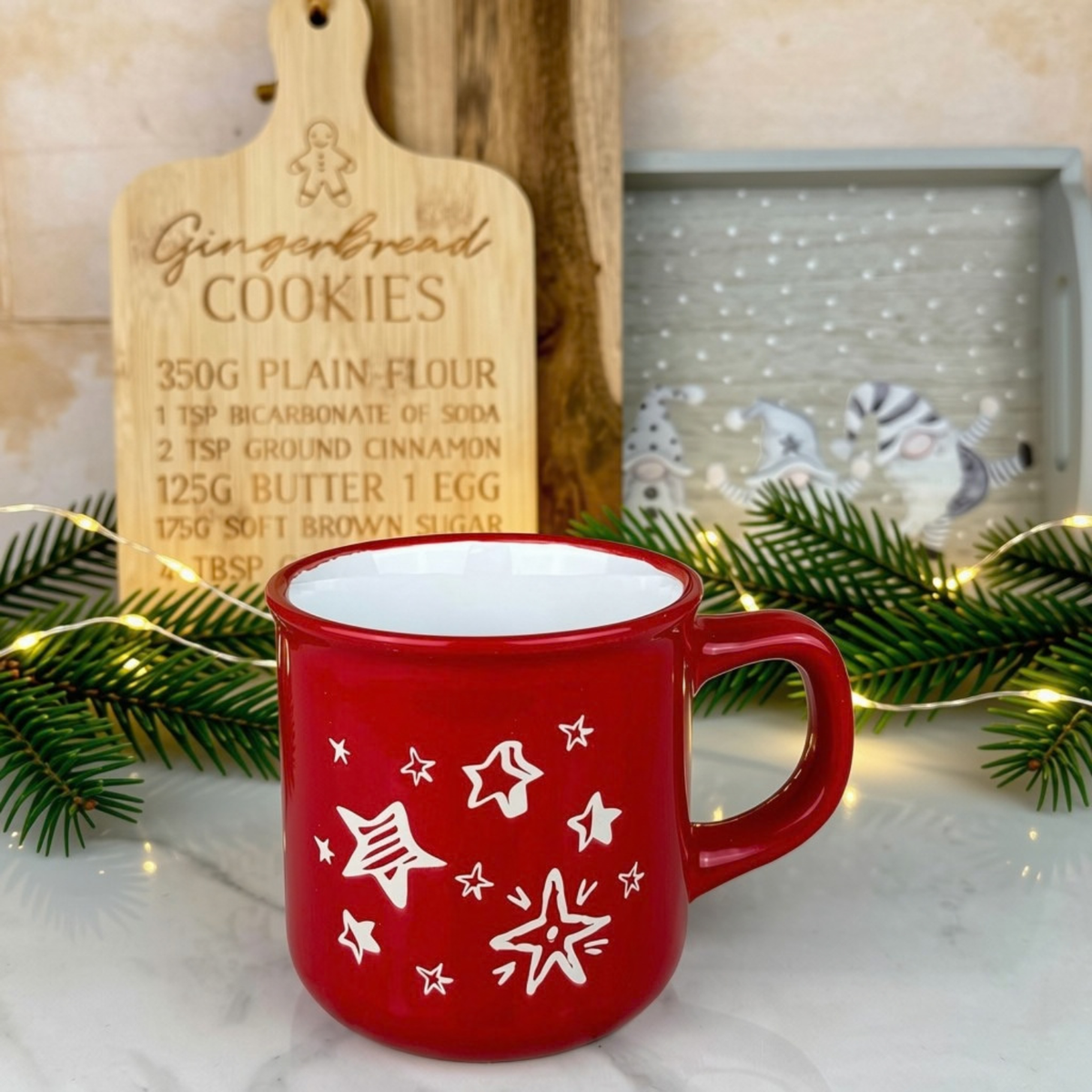 Red mug with a white star pattern styled in a kitchen with chopping boards