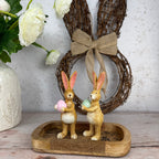 two bunnies one with pink one with green egg